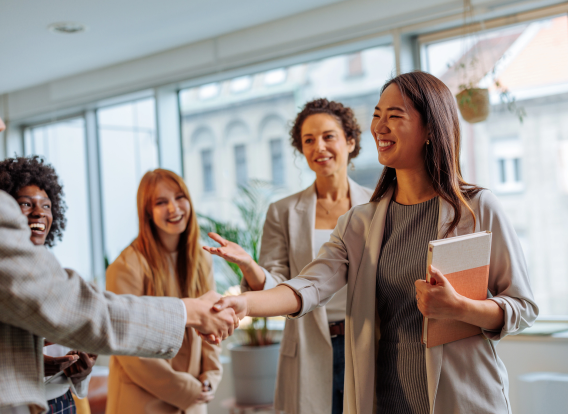 A group of women shaking hands and congratulating one another.